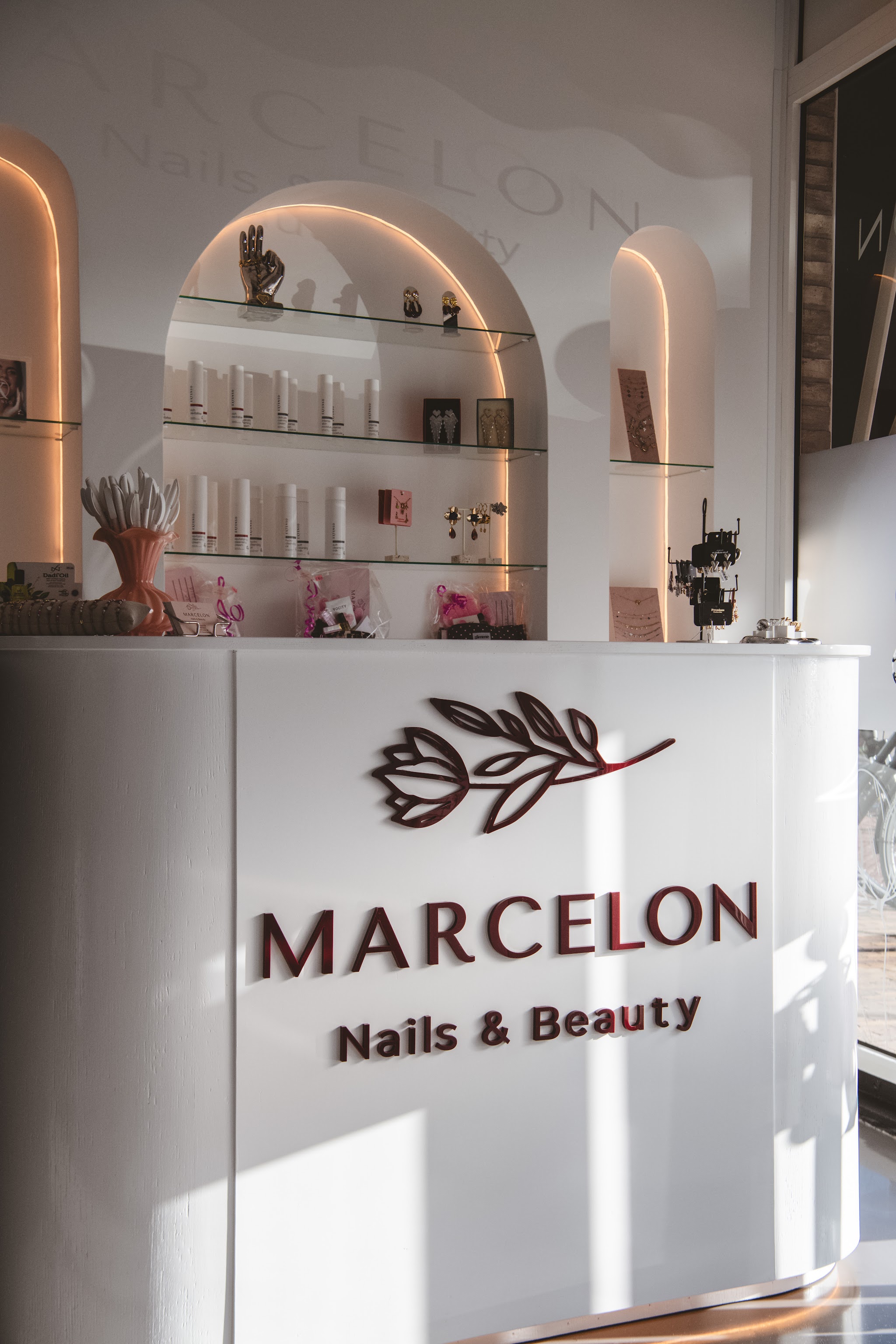 De balie van Marcelon nails & beauty met het logo en verlichte nissen