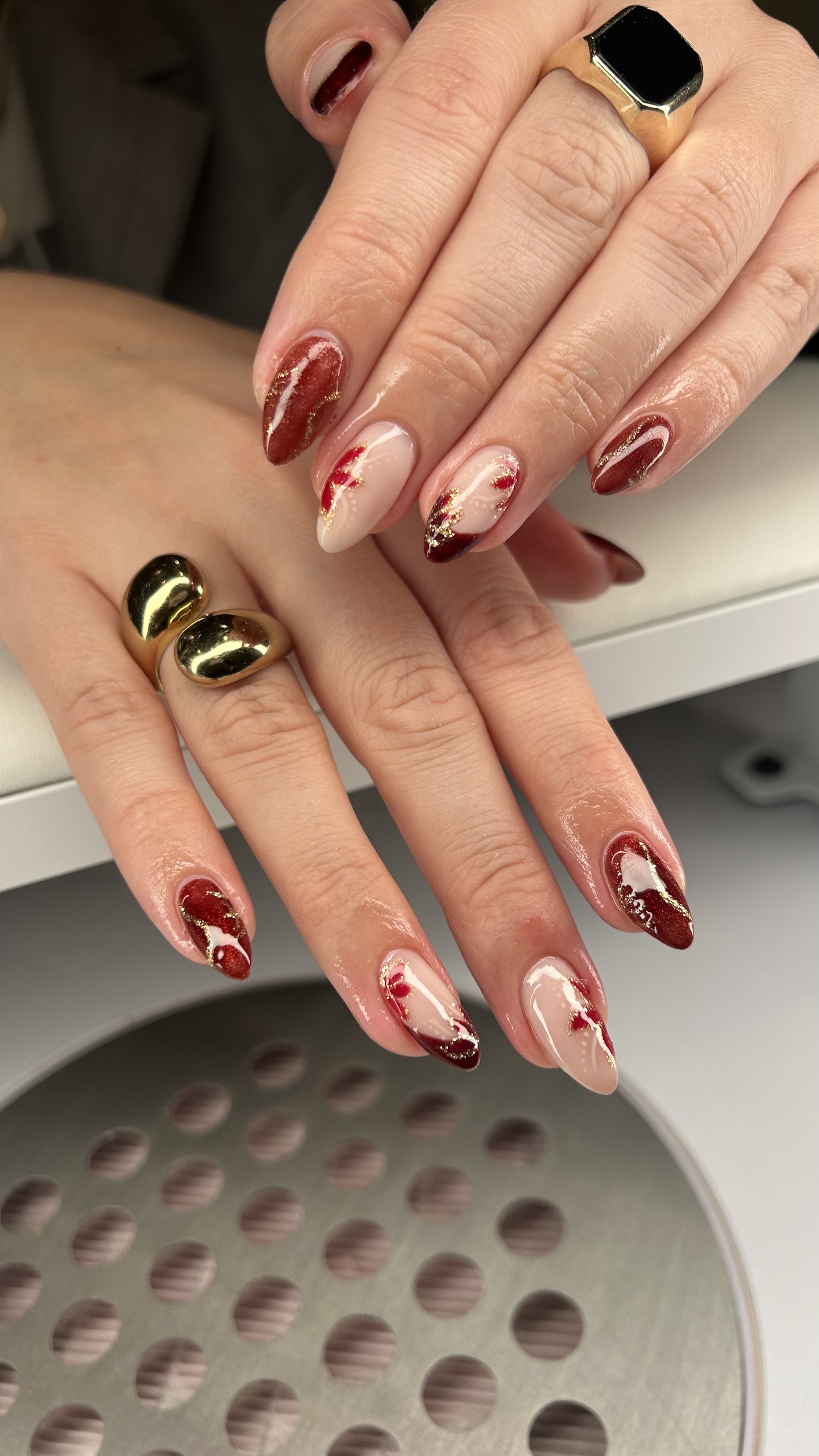 Bordeauxrode nailart met gouden accenten